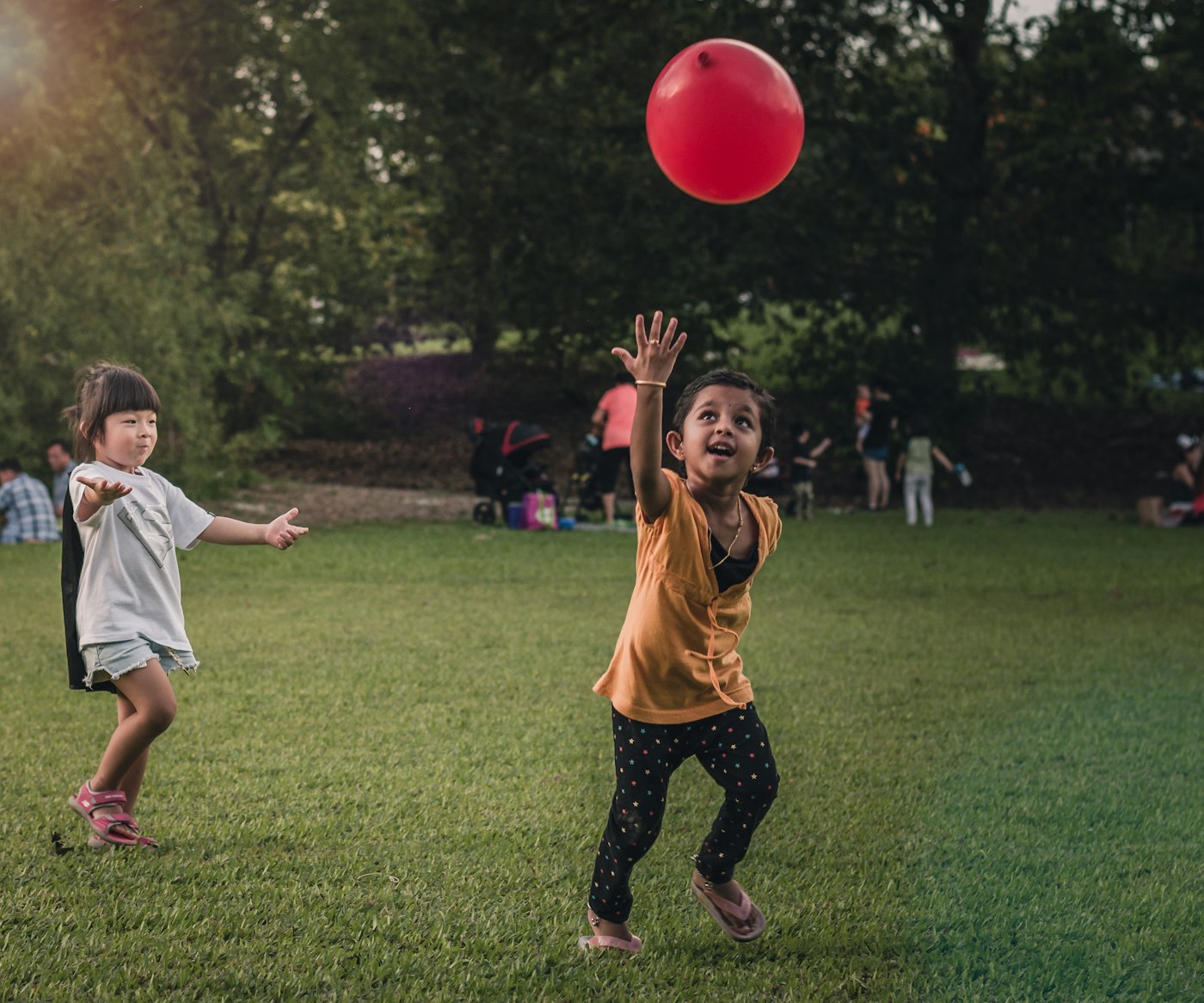 Duas meninas brincando juntas com um balão colorido